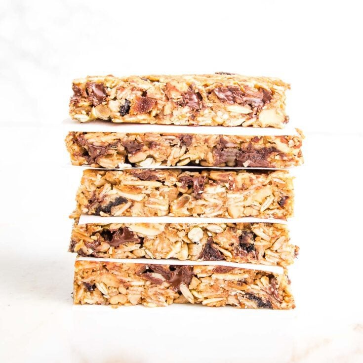 A stack of crunchy granola bars, with parchment paper in between layers.