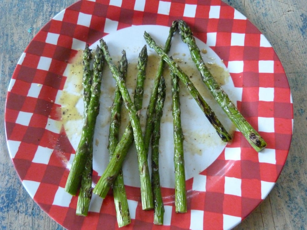 A plate of grilled asparagus with mustard vinaigrette.