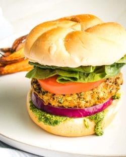 Veggie Burger in a bun with lettuce and tomato and dripping with green aioli