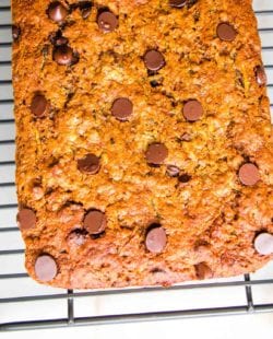 Chocolate Chip Zucchini Bread cooling on a wire rack on a white countertop.