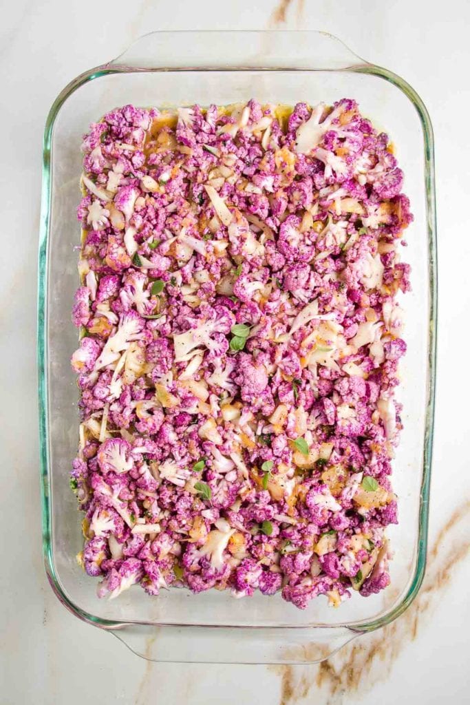 Purple cauliflower in an egg casserole, sprinkled with fresh oregano leaves.