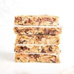 A stack of crunchy granola bars, with parchment paper in between layers.