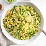 Large white serving bowl filled with Cauliflower rice and asparagus.