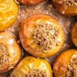 Close up of baked apples, stuffed with oatmeal in a glass pie plate.