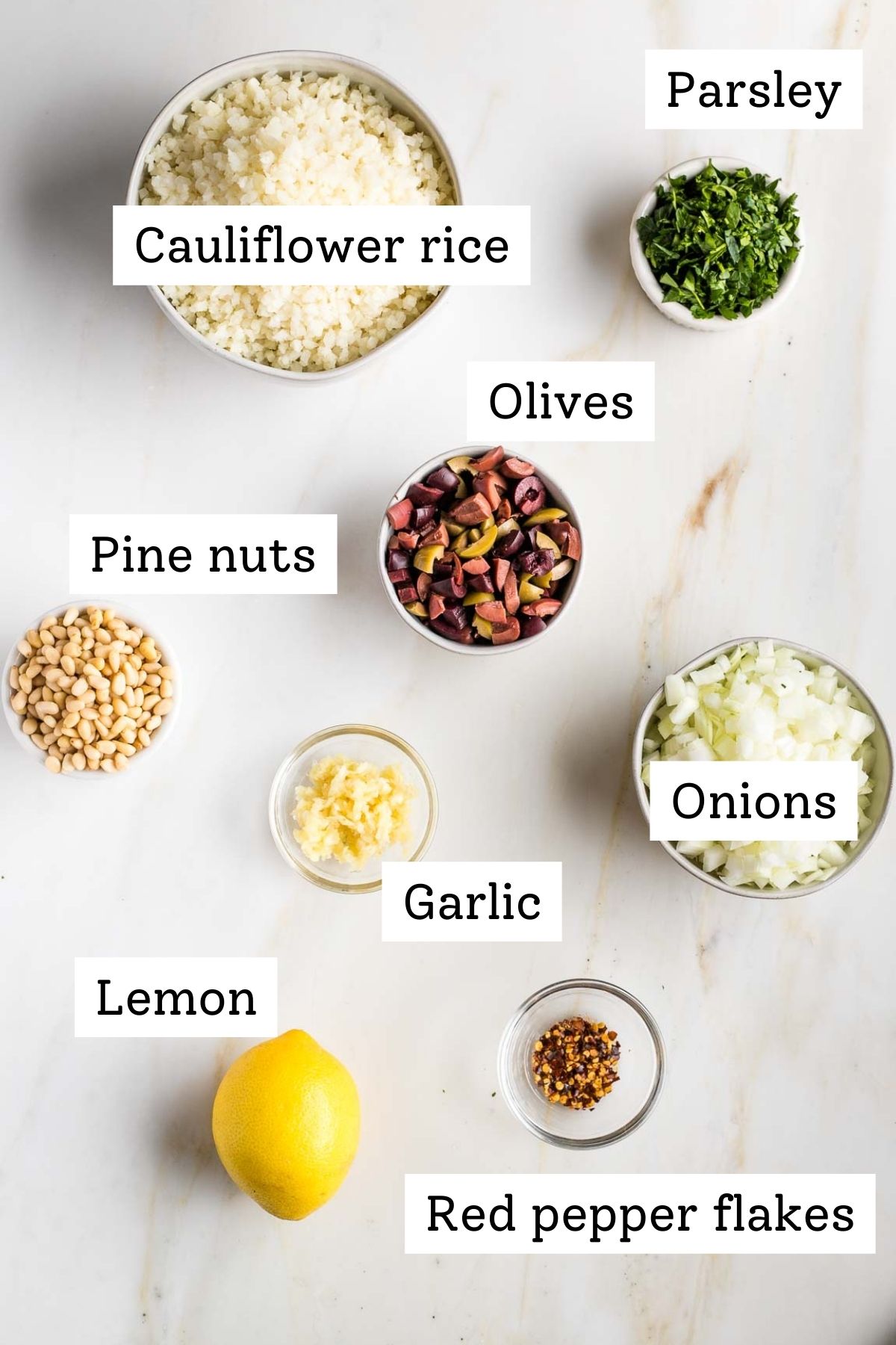 Labeled ingredients: cauliflower rice, fresh parsley, olives, pine nuts, onions, garlic, lemon, red pepper flakes.
