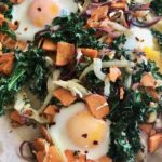 Sweet potato, kale and fennel hash with eggs on a sheet pan.