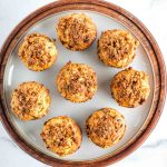 Round plate filled with carrot muffins with walnuts, raisins and shredded carrots.