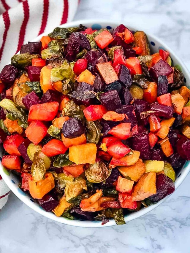 Bowl of roasted, cubed veggies like beets, brussels sprouts, carrots and sweet potatoes.