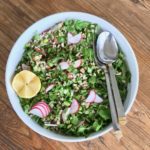 Bright lemon and radishes contrast with the greens and grains.