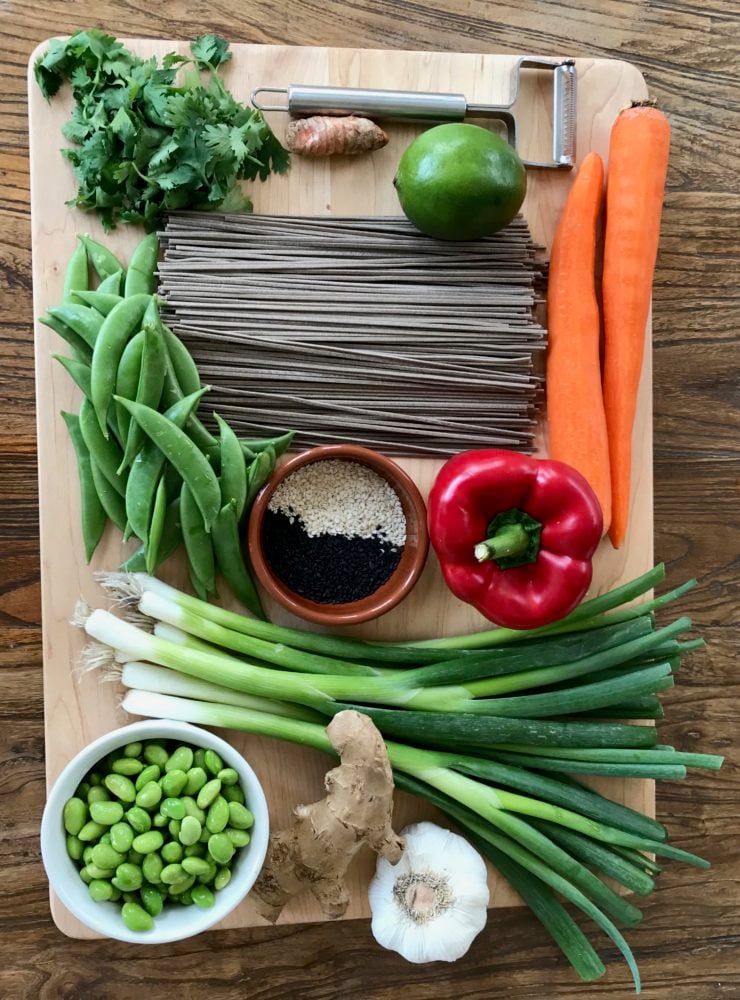 Soba noodles, cilantro, carrots, red pepper, scallions, edamame, garlic, snap peas, sesame seeds, turneric