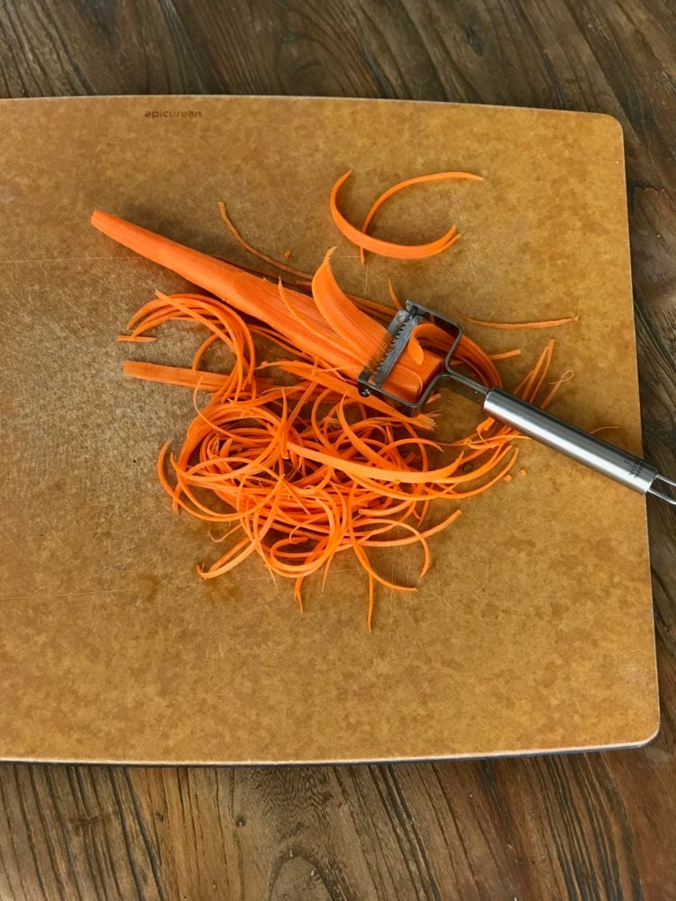 Carrot with julienne peeler, making strips