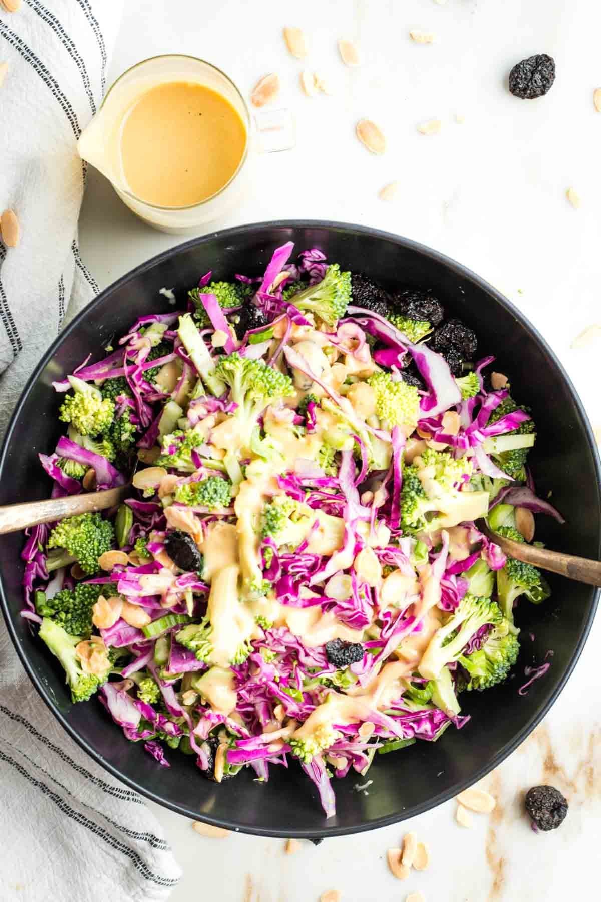Brightly colored broccoli and cabbage with a orangish creamy dressing, sprinkled with almonds and dried cherries.