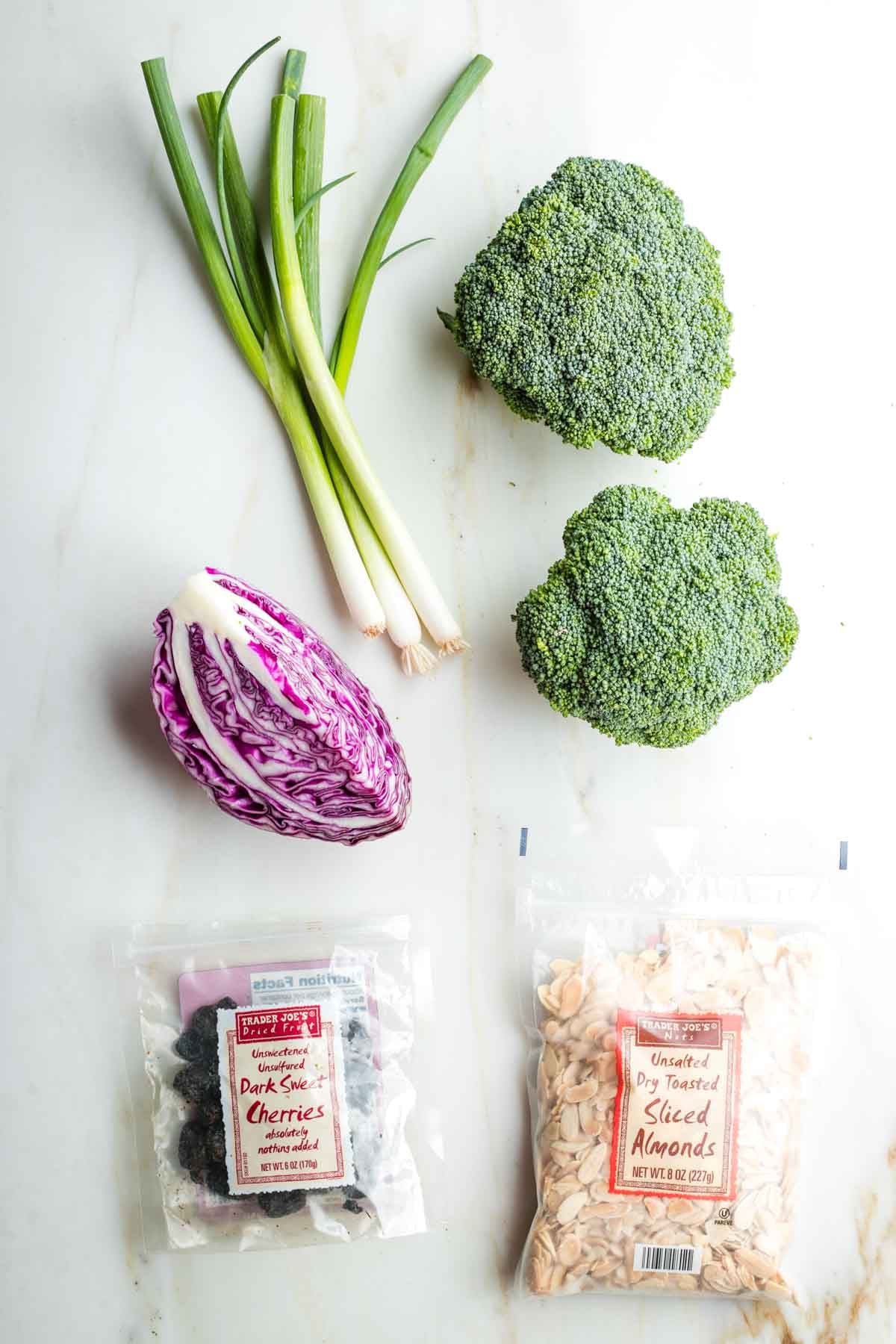 Crowns of broccoli, bunch of scallions, quarter head cabbage, package of dried cherries and sliced almonds. 