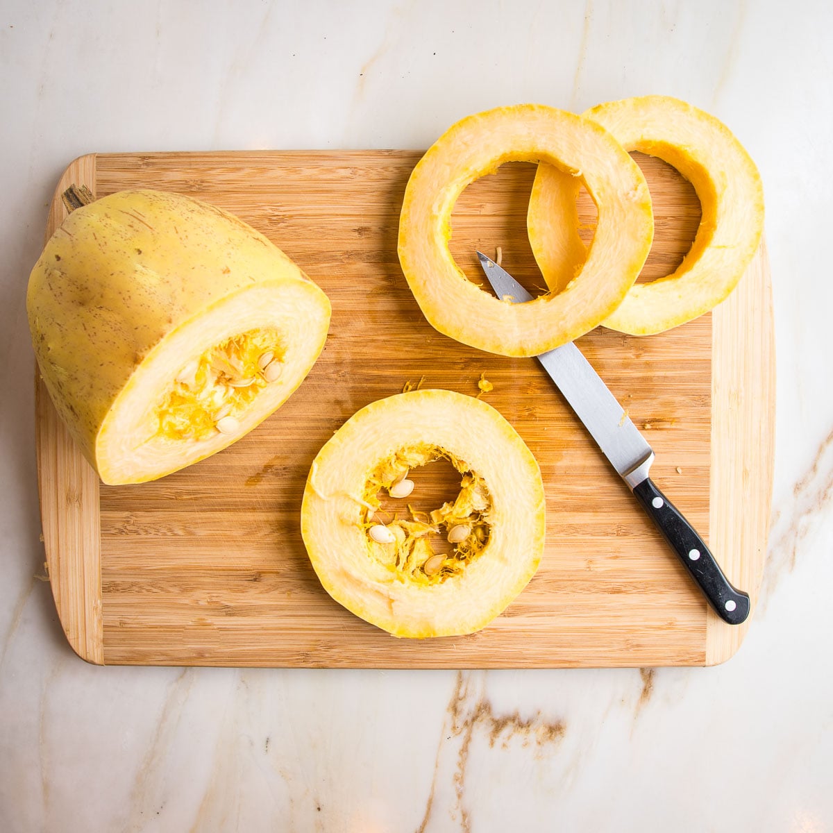 Cutting horizontal slices off a spaghetti squash.