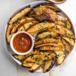 Crispy potato wedges with a dish of ketchup.