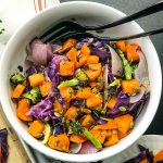 Bowl of roasted butternut with purple cabbage, onions, broccoli and fresh herbs.