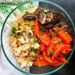 Bowl of lentils and faro, topped with roasted sliced mushrooms, carrot spears and cauliflower.