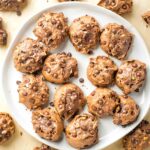 Plate full of double chocolate chip cookies, sprinkled with salt.