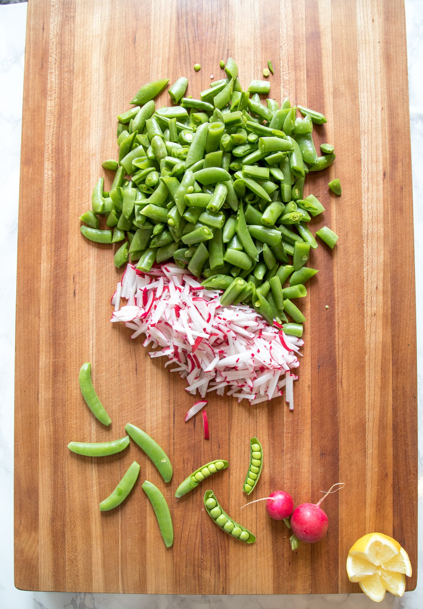 Raw sugar snap peas plus radishes are chopped for salad