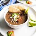 Bowl of black bean soup with toppings
