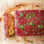 A thick slice of vegan meatloaf with tomato glaze.