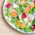 Slices of oranges, avocados, onion and watercress, artfully arranged.