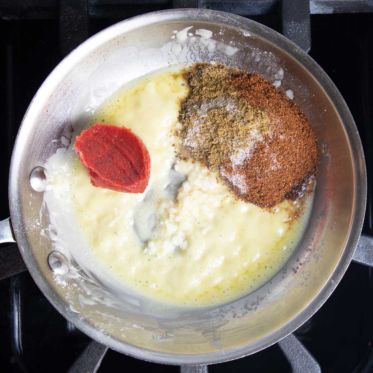 Small pan with roux, tomato paste, garlic and spices