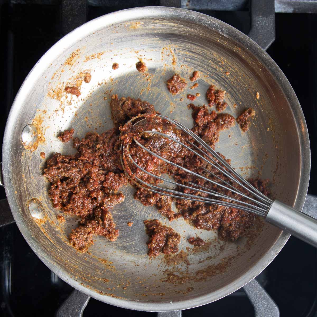 Whisking enchilada spices into a roux that is super thick and pasty.