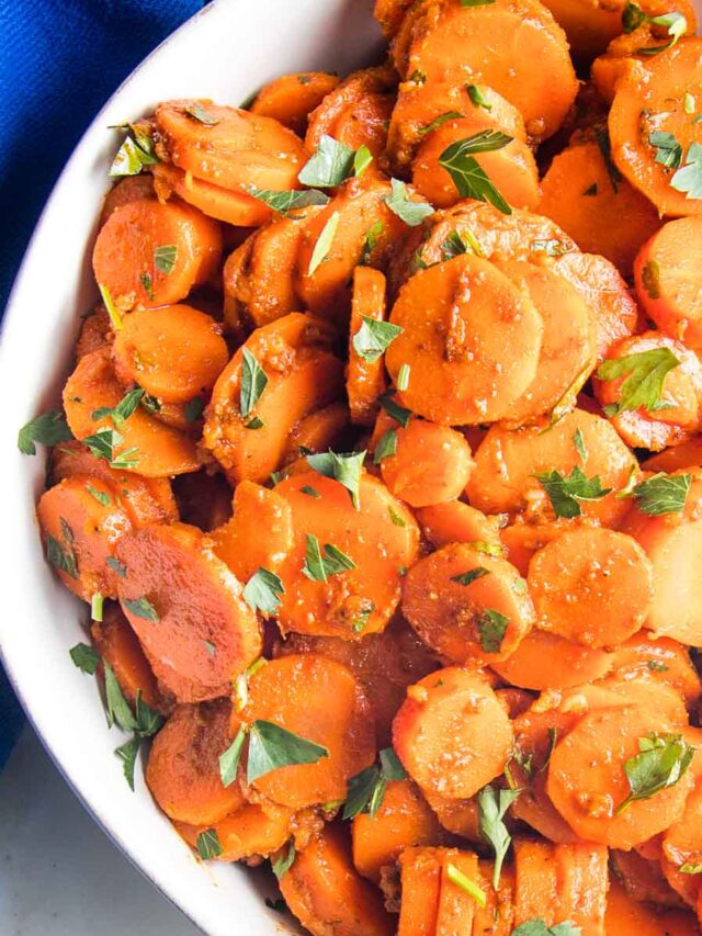 close up of moroccan spiced carrots in a white bowl.