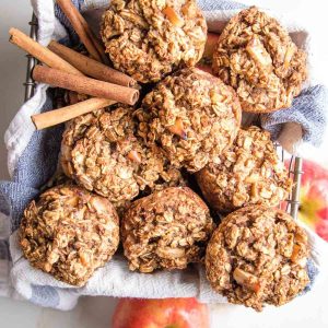 Oatmeal apple muffins in a basket with cinnamon stick and apples around.