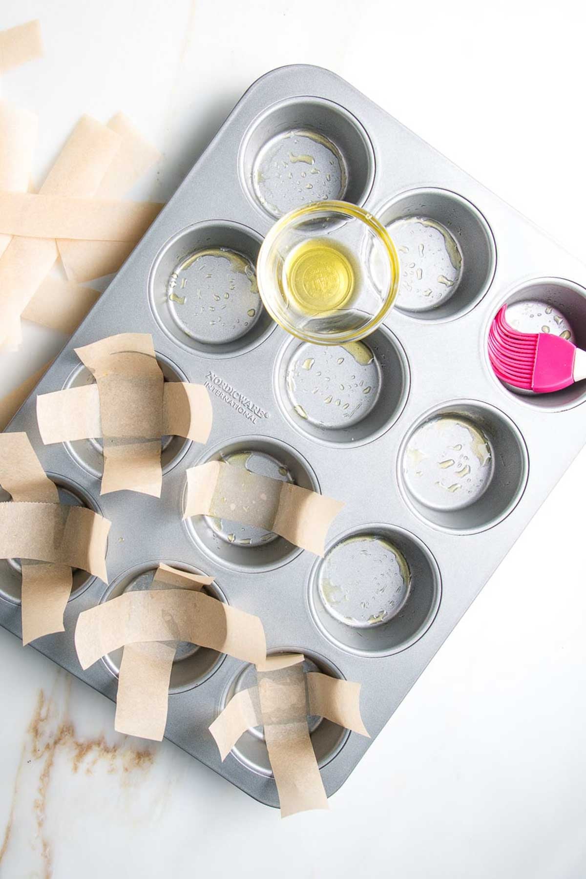 Muffin tin, brushed with oil and lined with strips of unbleached parchment paper.