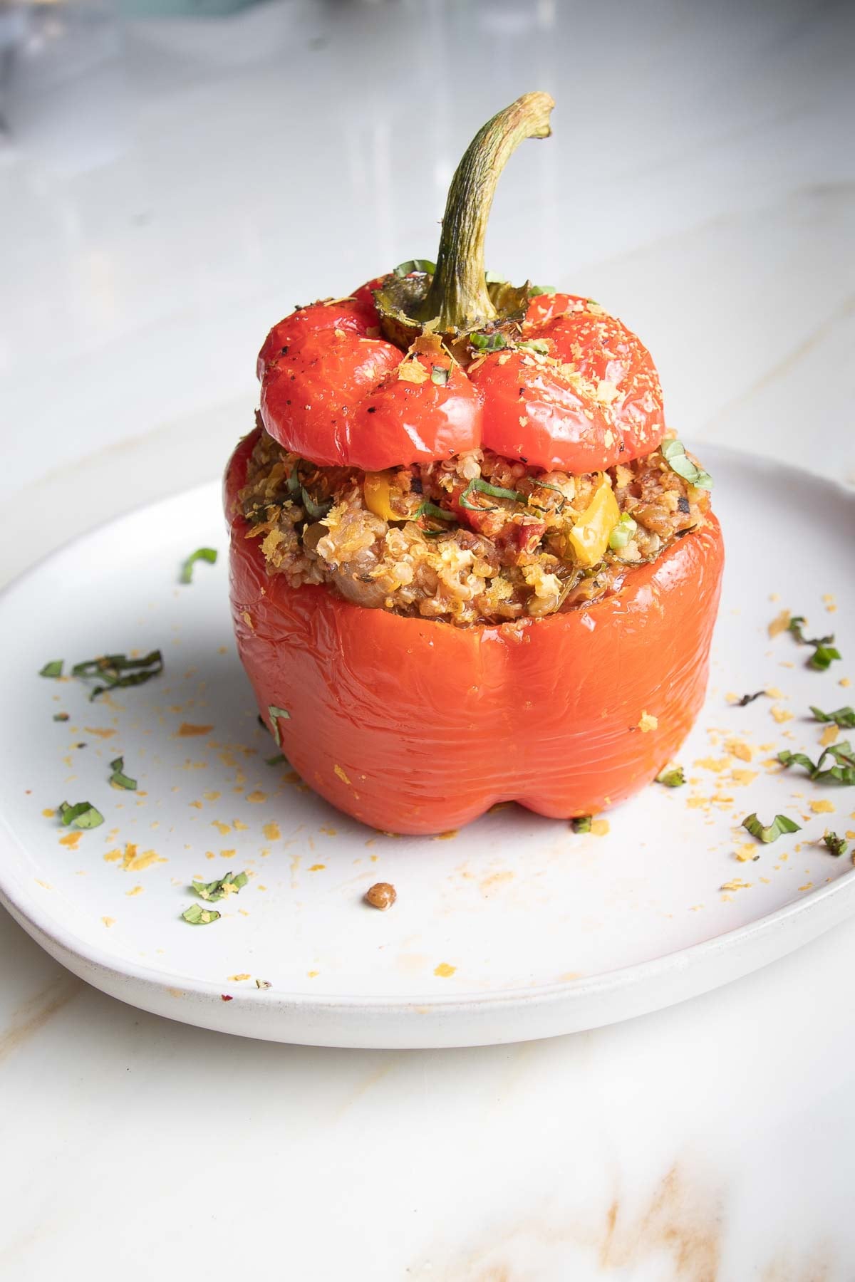 Red bell pepper stuffed with quinoa lentil mixture with the top back on.
