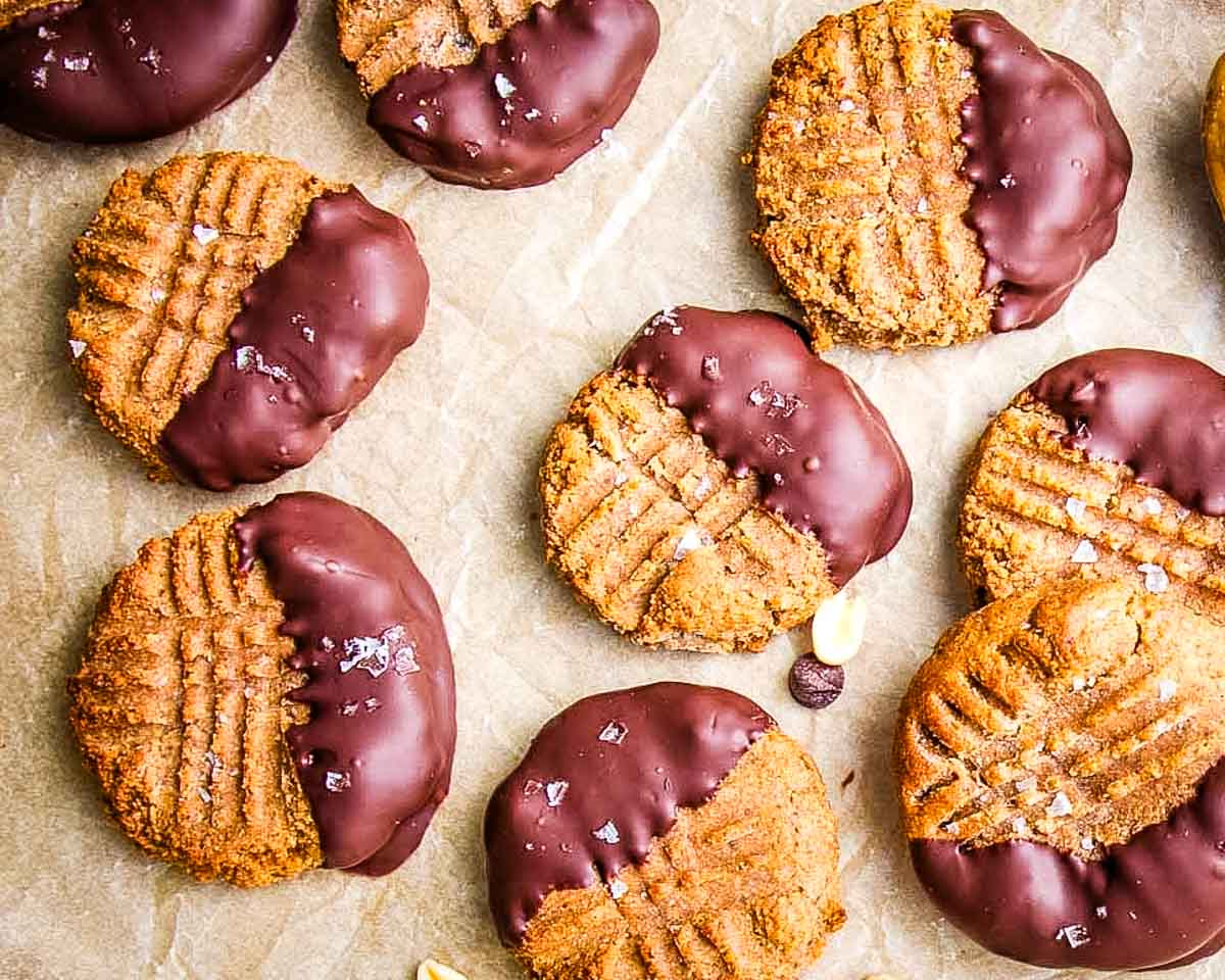 Peanut butter cookies with fork marks, half dipped in dark chocolate. 