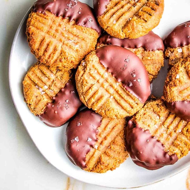Peanut butter cookies with fork marks, dipped in dark chocolate and sprinkled with flakey salt.