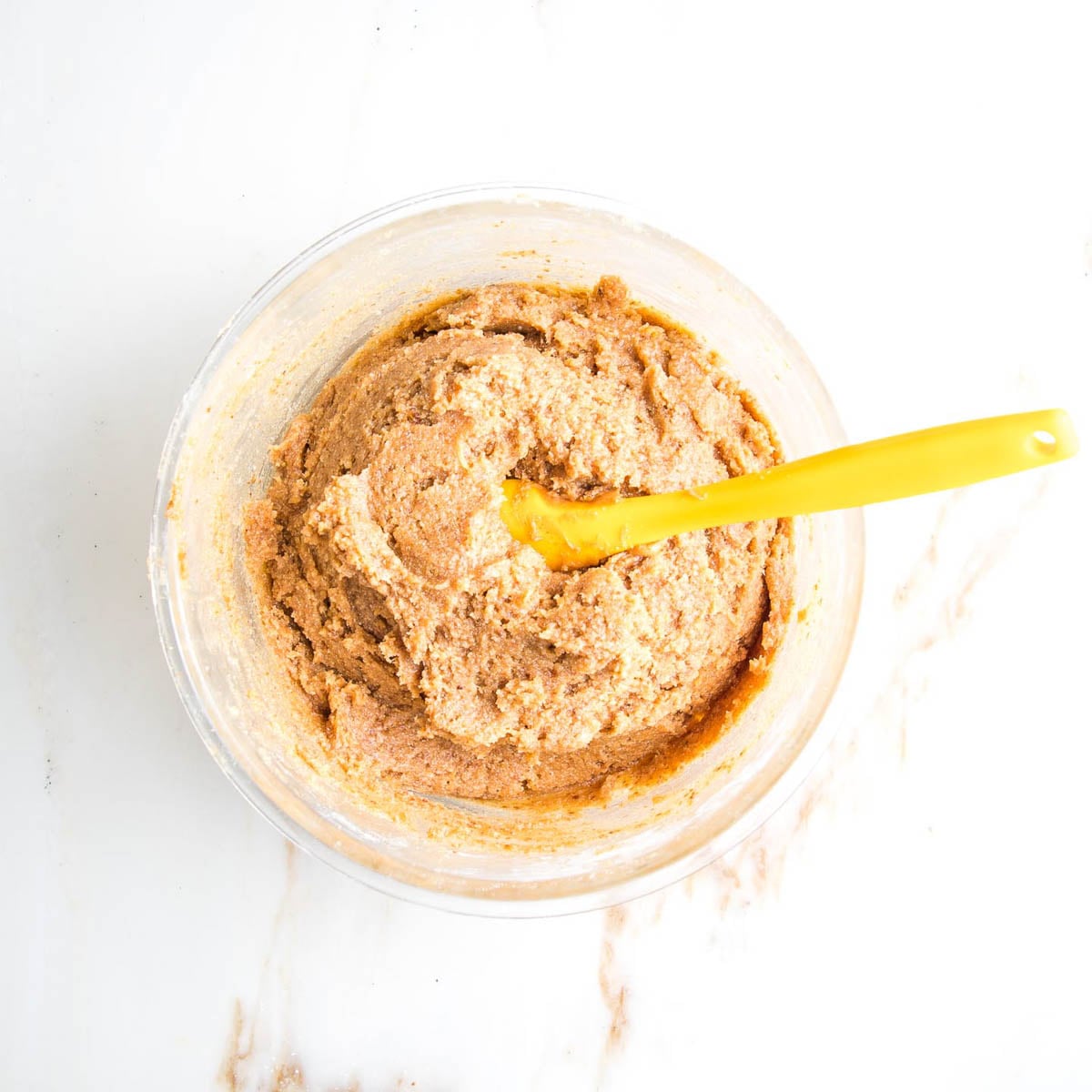 Peanut butter cookie batter in bowl with spatula. 