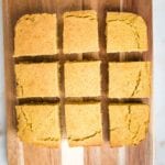 square cornbread, on a wooden board, cut into 9 even slices.