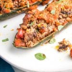 close up of zucchini boat. Looks to be stuffed with ground meat with tomato sauce baked on top...but it's actually plant-based.