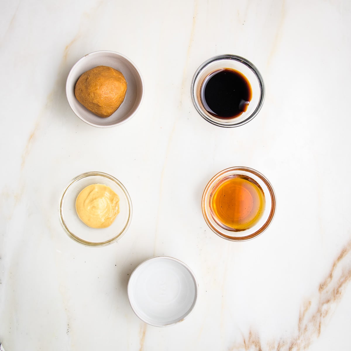 small bowls filled with light miso, balsamic vinegar, dijon mustard, maple syrup and water.