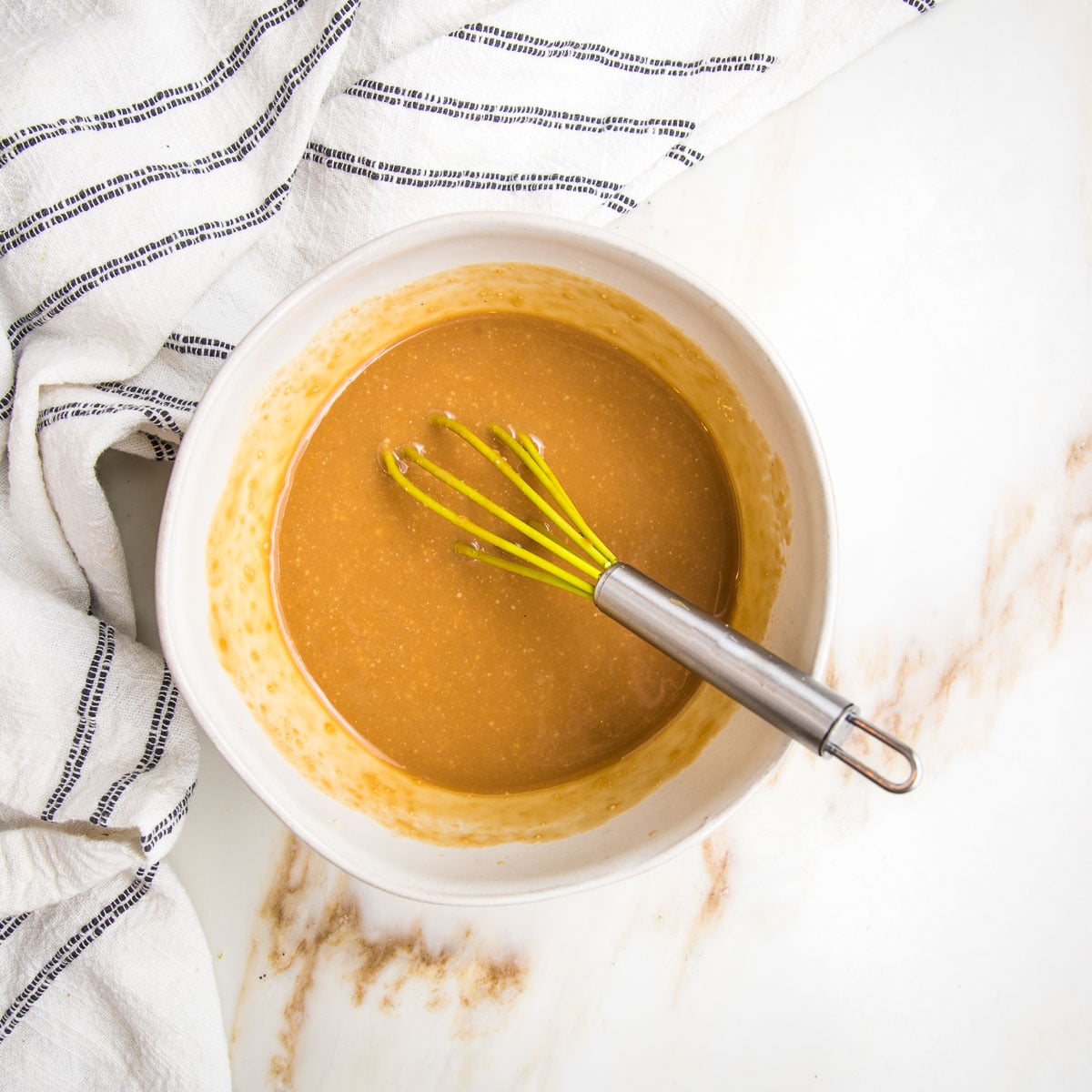 Miso dressing in a small bowl with a whisk.