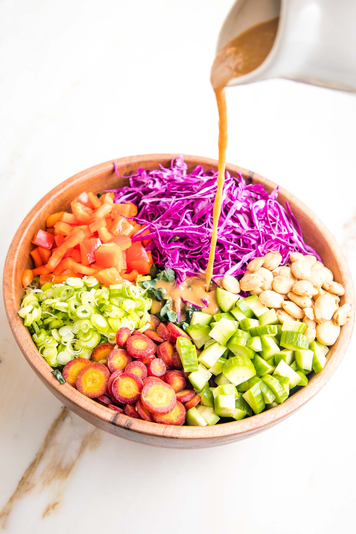 Dressing pour over colorful sections of chopped veggies.