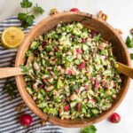 wooden bowl filled with bean salad including kidney beans, white beans, lots of green and radishes.