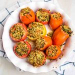 Round baking dish filled with baked stuffed tomatoes.