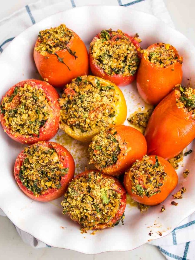 Round baking dish filled with baked stuffed tomatoes.