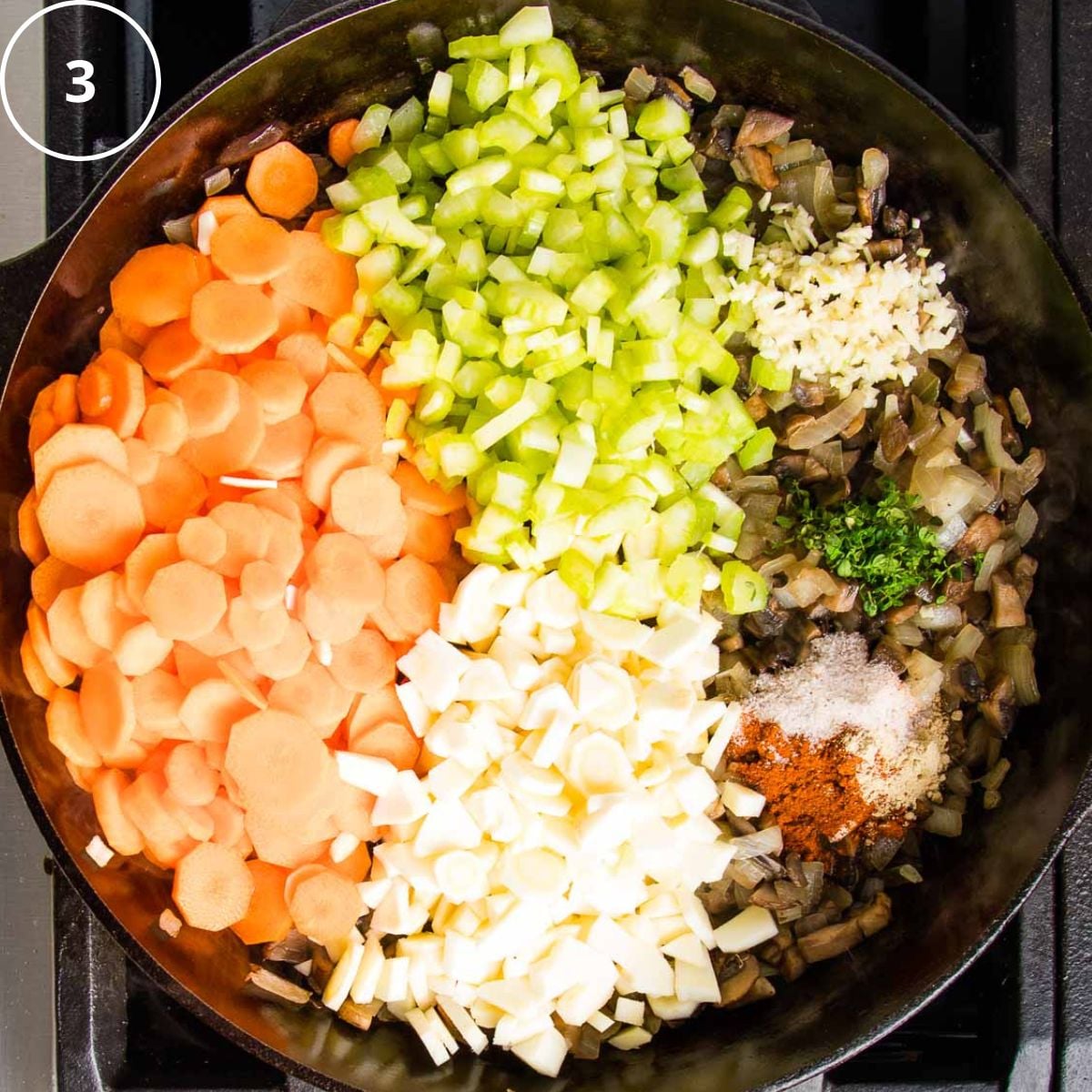 Sections of chopped carrots, parsnips, celery, sauteed onions and mushrooms, plus spices and herbs in a cast iron skillet.