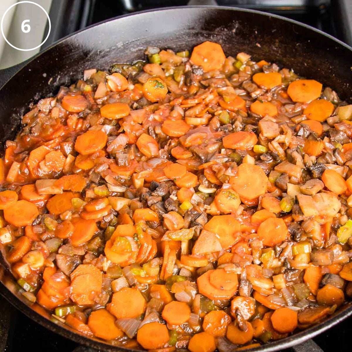 Cast iron skillet filled with vegetable filling for shepherd's pie.
