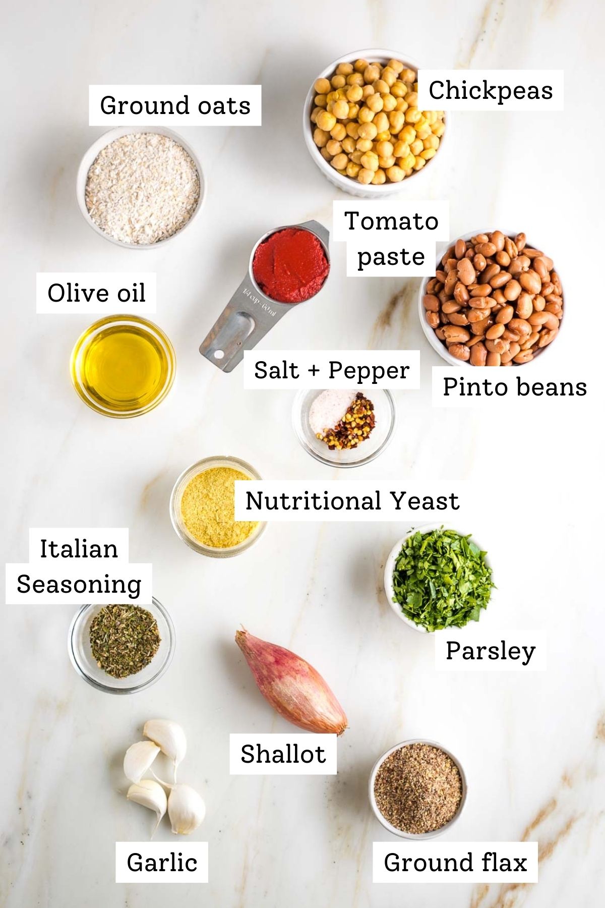 Ingredients for vegan meatballs with labels: chickpeas, pinto beans, oat flour, flax, shallot, parsley, tomato paste, garlic, italian seasoning and nutritional yeast.