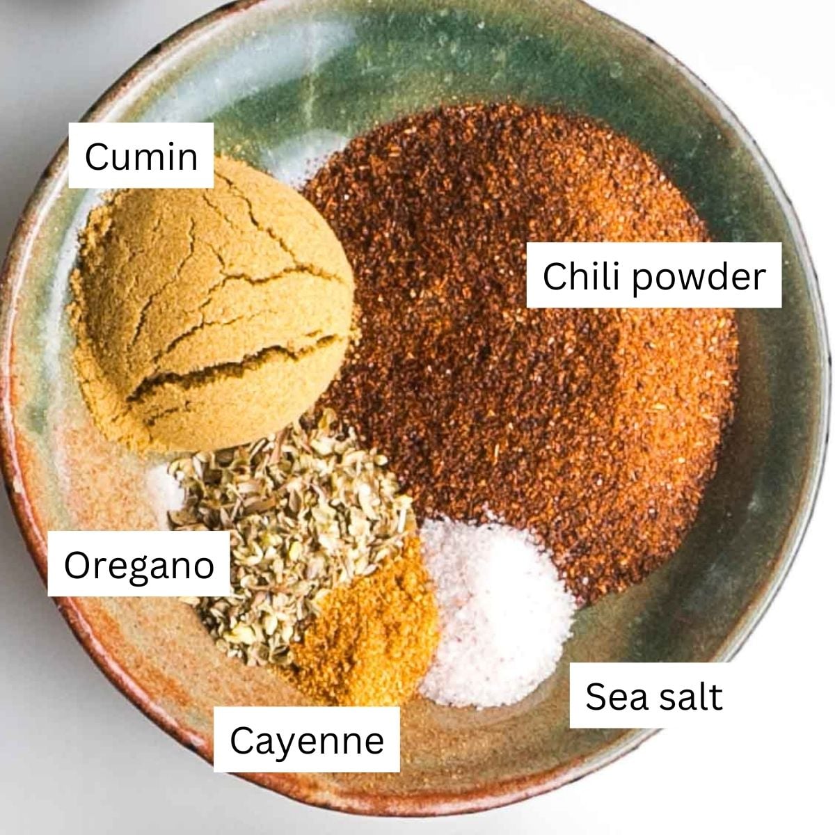 Labeled spices for chili: cumin, chili powder, oregano, cayenne, sea salt.