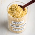 Small glass spice jar filled with vegan parmesan cheese.