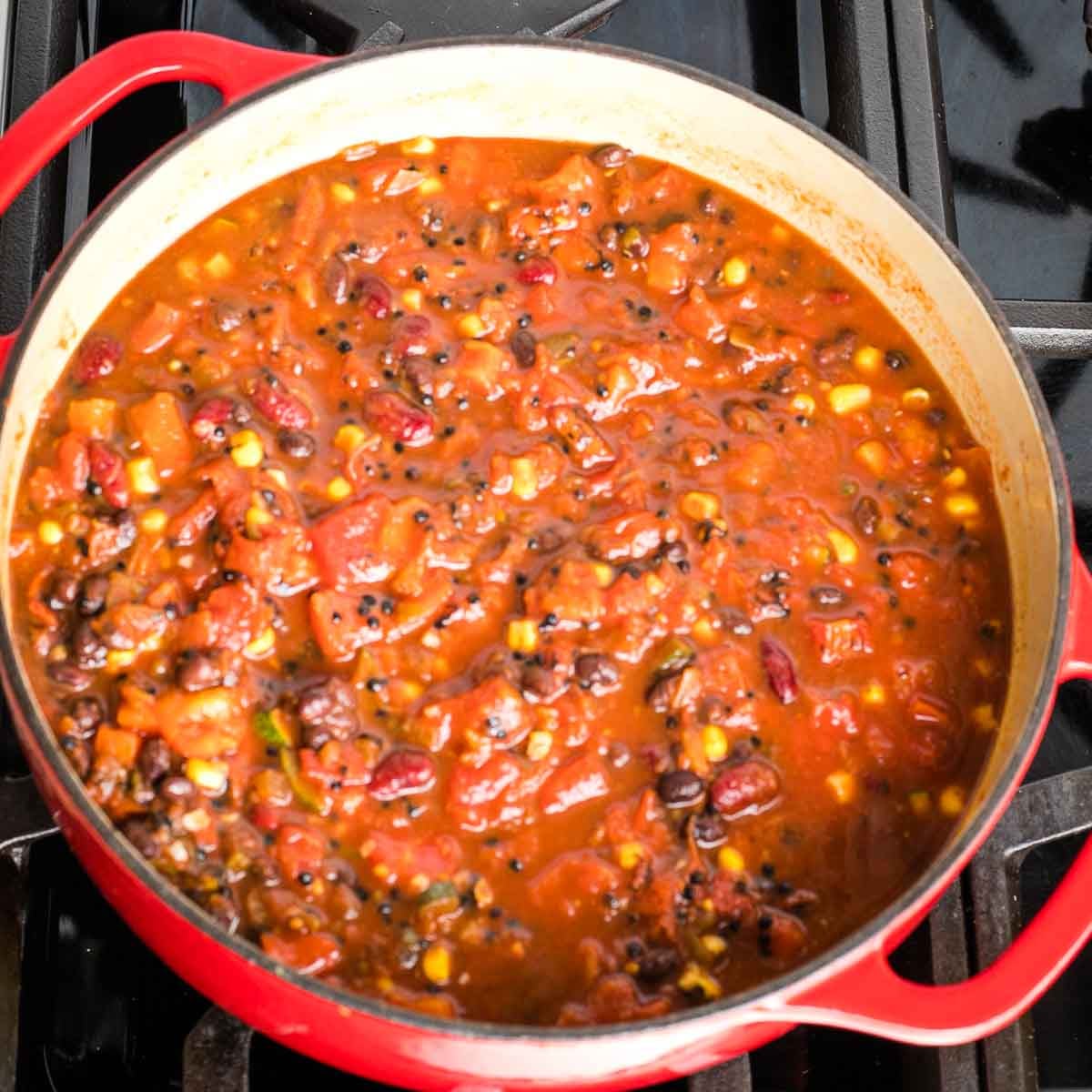 Vegan lentil chili cooking in a dutch oven on the stove.