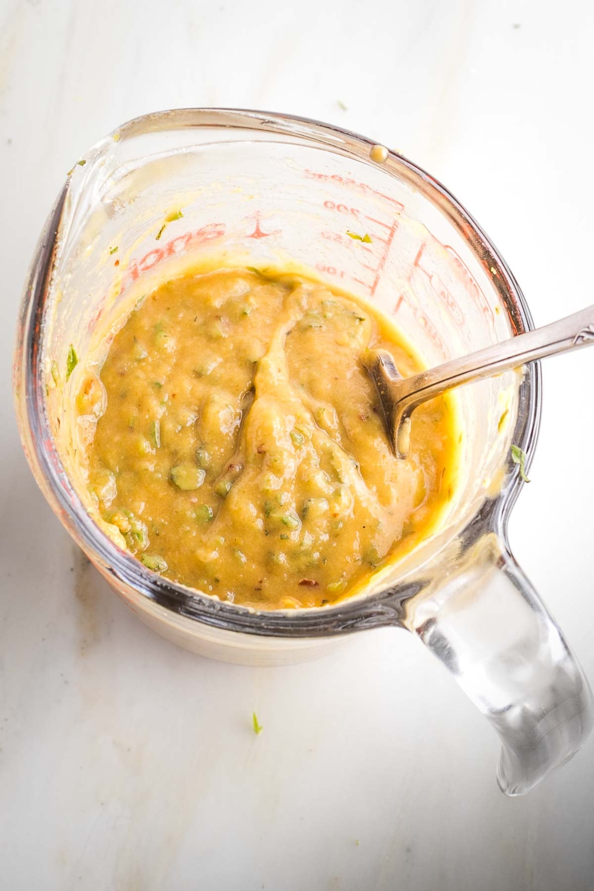 Mixing up a thick tahini sauce with oil, lemon, herbs and spices. 